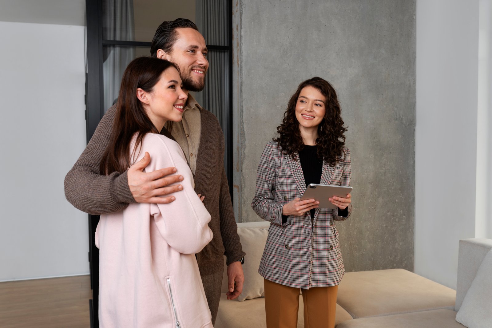 couple touring a modern apartment with a real estate agent.